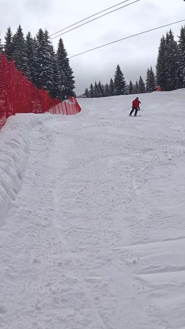 Vertikales-Video-Eines-Skifahrers,-Der-Den-Berg-Hinunterfährt-Und-Die-Kamera-Mit-Schnee-Bedeckt-1